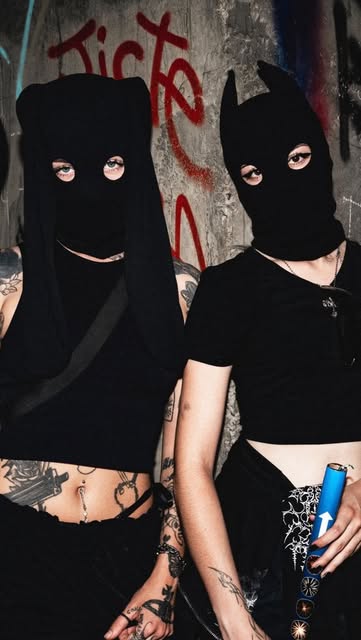 Casper and a second masked figure in black balaclavas against a graffitied wall