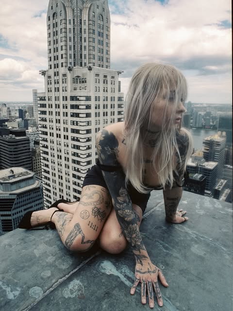 Casper crouched on a New York rooftop edge beside the Chrysler Building